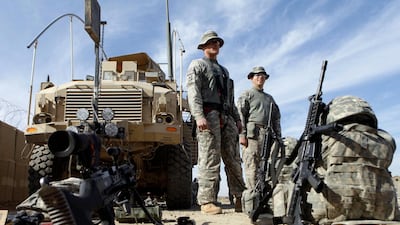 U.S. Army soldiers with 1st Brigade, 1st Cavalry Division stand near their armored vehicles before they start their journey home at Contingency Operating Site Kalsu, south of Baghdad, Iraq. AP