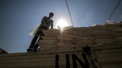 A Palestinian worker from the United Nation Relief and Works Agency (UNRWA) handles food supplies, in Gaza City. EPA