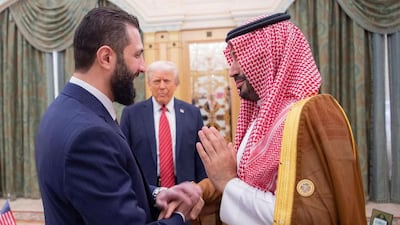 Prince Mohammed, right, shake hands with Mr Al Shara, as Mr Trump looks on. AP